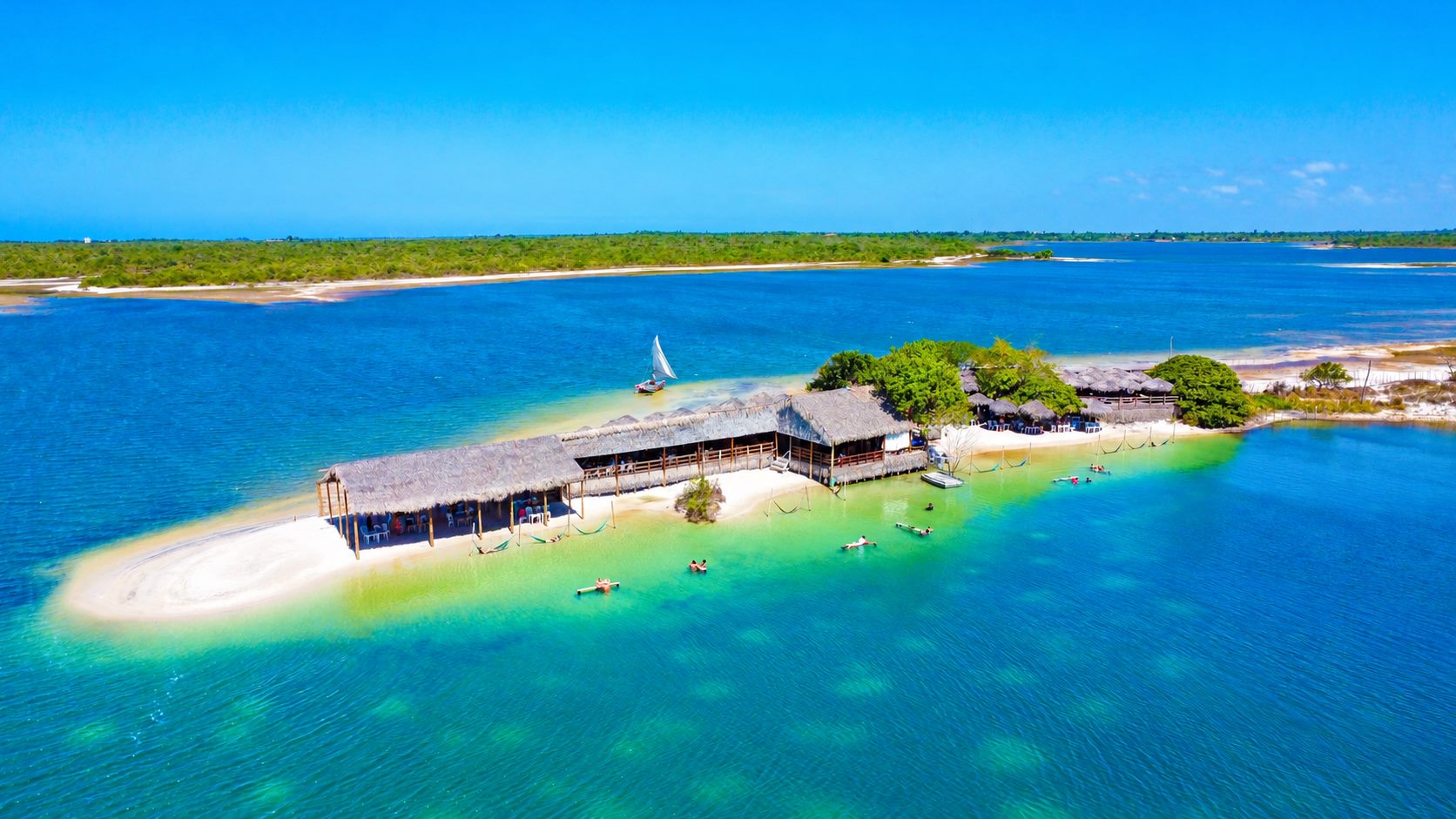 Beach club sobre um banco de areia na lagoa, com redes na água